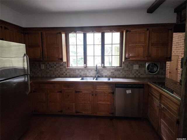 kitchen with dark hardwood / wood-style flooring, decorative backsplash, sink, and stainless steel appliances