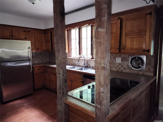 kitchen featuring sink, stainless steel appliances, tasteful backsplash, and dark wood-type flooring