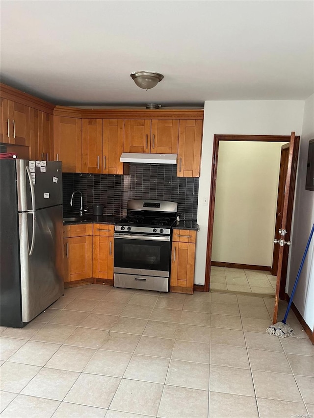 kitchen featuring appliances with stainless steel finishes, backsplash, light tile patterned floors, and sink