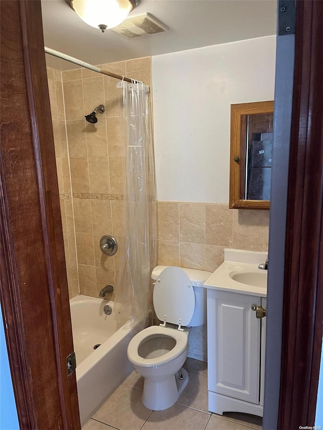 full bathroom with shower / bath combination with curtain, vanity, tile walls, tile patterned flooring, and toilet