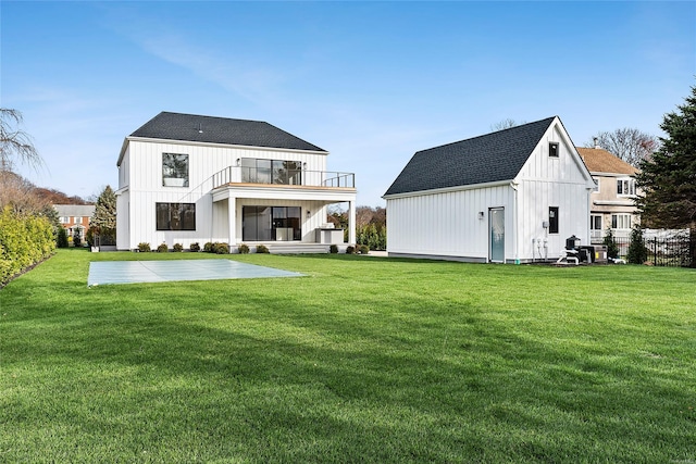 rear view of house featuring a yard and a balcony