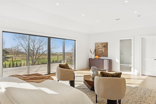 bedroom with access to exterior and light hardwood / wood-style flooring