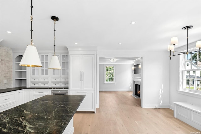 kitchen featuring white cabinets, decorative light fixtures, and a healthy amount of sunlight