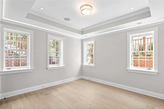 spare room with light hardwood / wood-style floors, ornamental molding, and a wealth of natural light