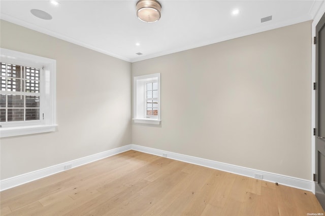 spare room featuring light hardwood / wood-style floors and ornamental molding