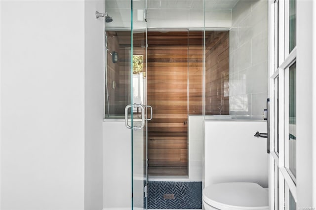 bathroom featuring an enclosed shower and toilet