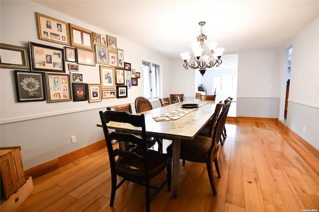 dining room featuring a notable chandelier and light wood-type flooring