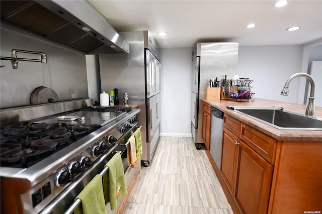 kitchen featuring sink, stainless steel appliances, and exhaust hood