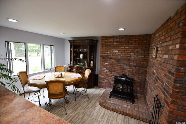 dining area with a wood stove and brick wall