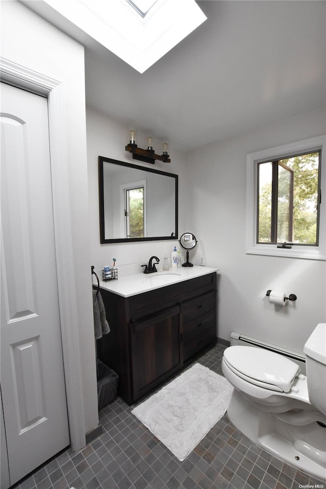 bathroom featuring a wealth of natural light, vanity, a baseboard radiator, and toilet