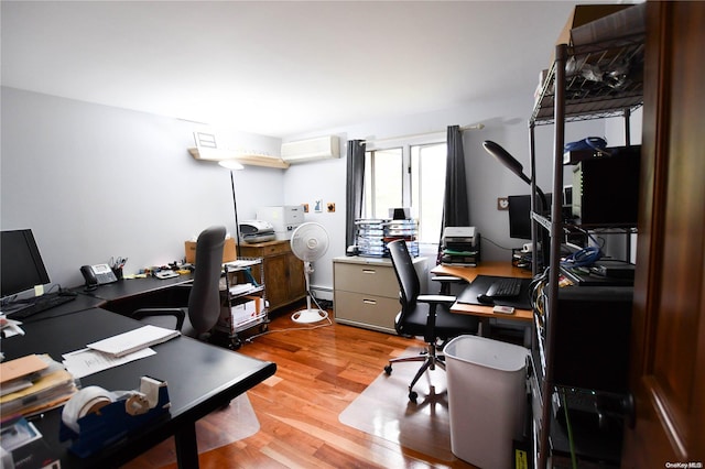 office area featuring baseboard heating, light hardwood / wood-style flooring, and a wall mounted AC