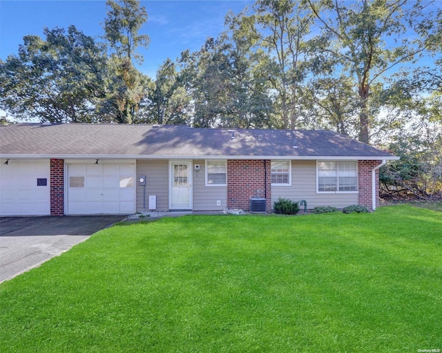 ranch-style house featuring central AC, a garage, and a front lawn