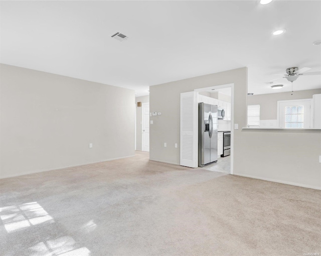 unfurnished living room with light carpet and ceiling fan