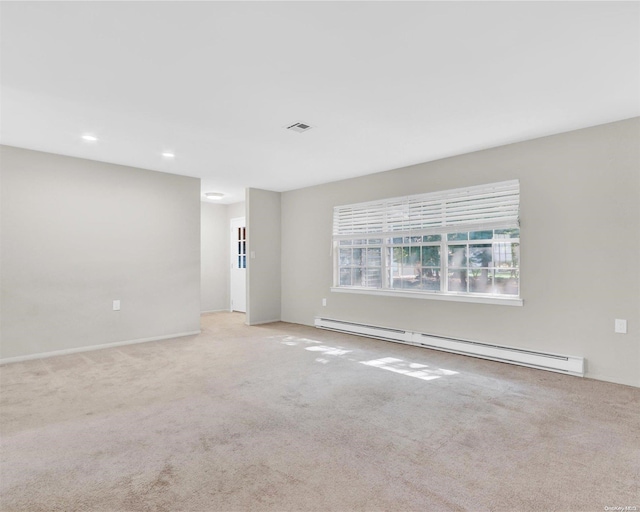 carpeted empty room with a baseboard heating unit