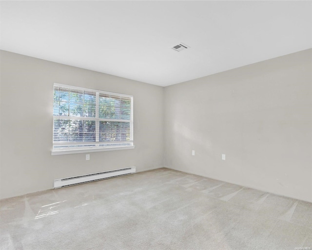 empty room with light carpet and a baseboard heating unit