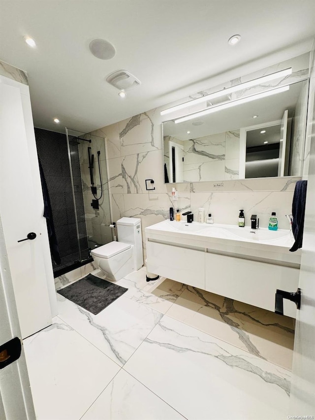 bathroom with vanity, toilet, a shower with door, and tile walls