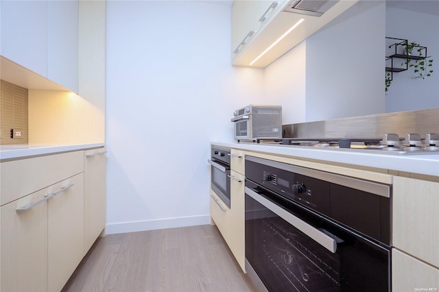 kitchen featuring white cabinets, appliances with stainless steel finishes, and light hardwood / wood-style flooring