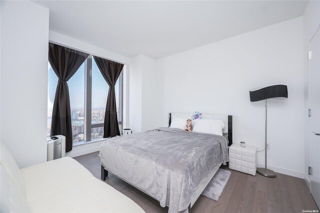 bedroom with dark hardwood / wood-style flooring and radiator heating unit