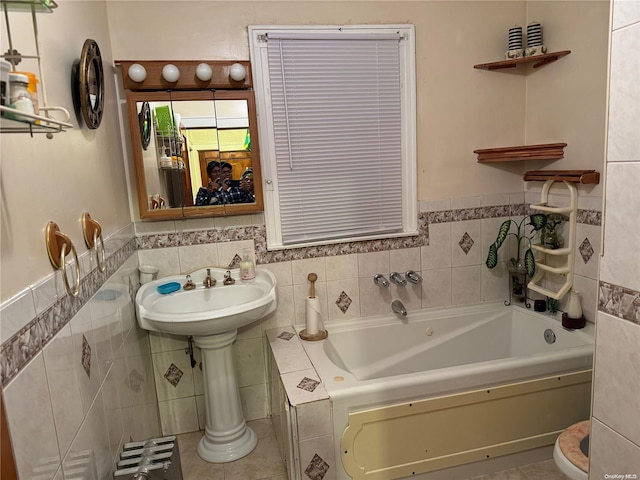 bathroom with a tub to relax in, tile patterned flooring, and tile walls