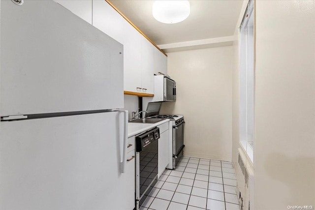 kitchen featuring light tile patterned floors, white appliances, white cabinetry, and sink