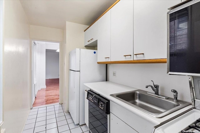 kitchen featuring white cabinets, light hardwood / wood-style floors, sink, and black dishwasher