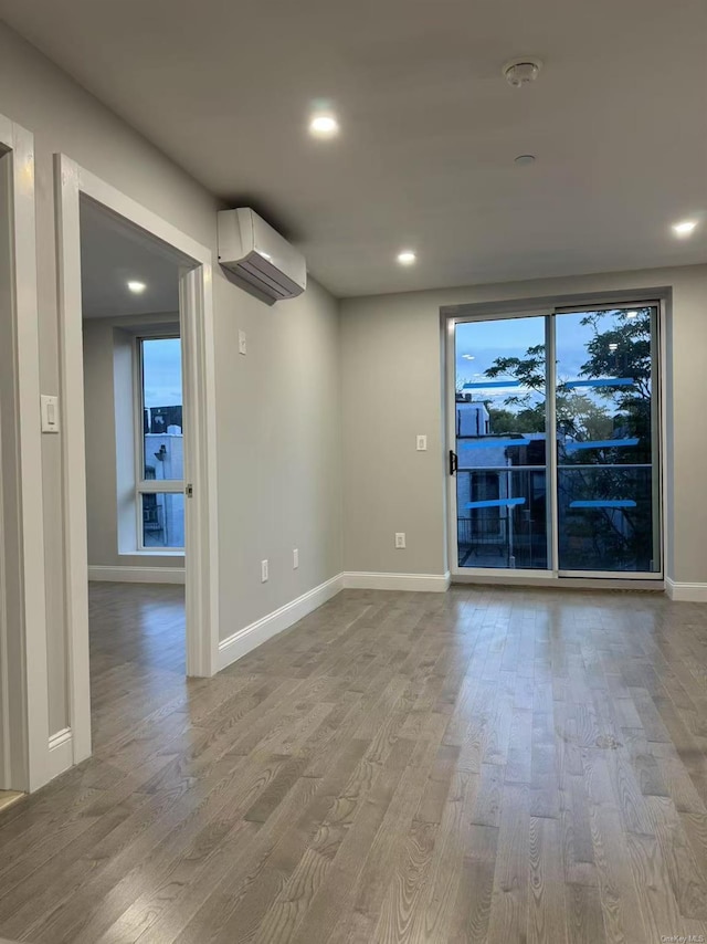 228 55th St Unit 3A, Brooklyn, NY 11220 - unfurnished room with wood finished floors, a wall unit AC, and recessed lighting