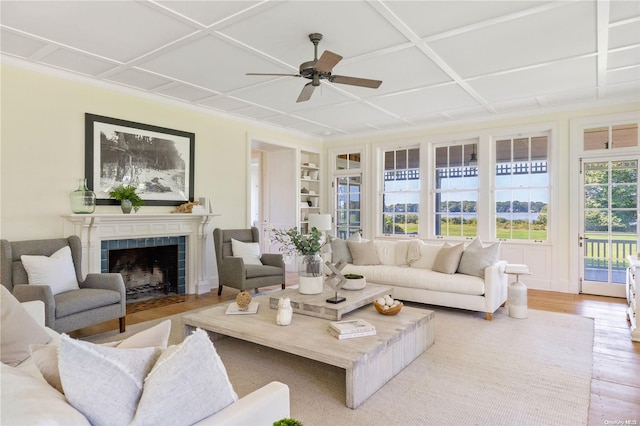 sunroom with a tile fireplace, ceiling fan, and coffered ceiling