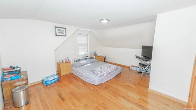 bedroom featuring hardwood / wood-style flooring and lofted ceiling