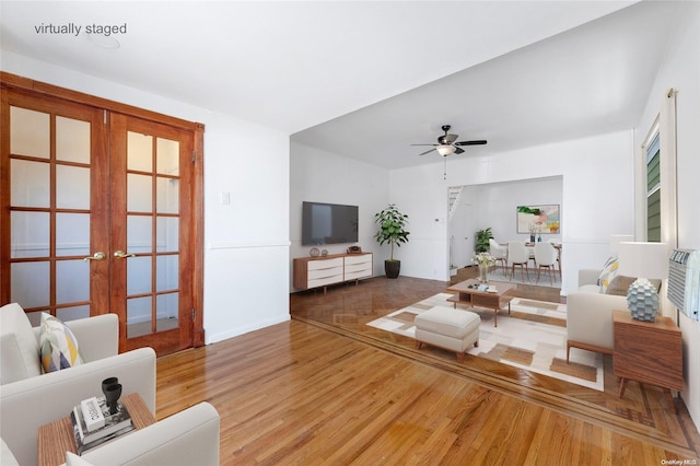 living room featuring ceiling fan, wood-type flooring, and french doors