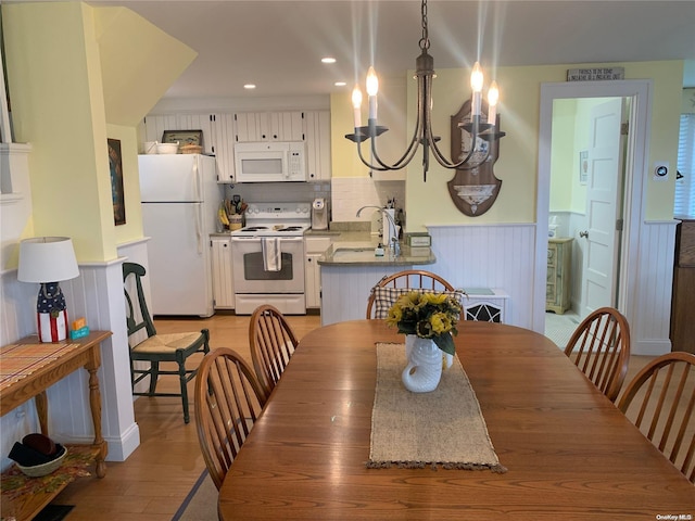 dining area with hardwood / wood-style floors, a chandelier, and sink