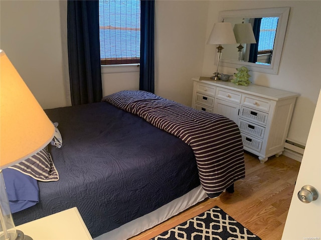 bedroom featuring light wood-type flooring and baseboard heating