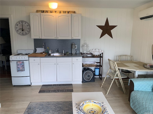 kitchen with white cabinetry, sink, light hardwood / wood-style flooring, white range, and decorative backsplash