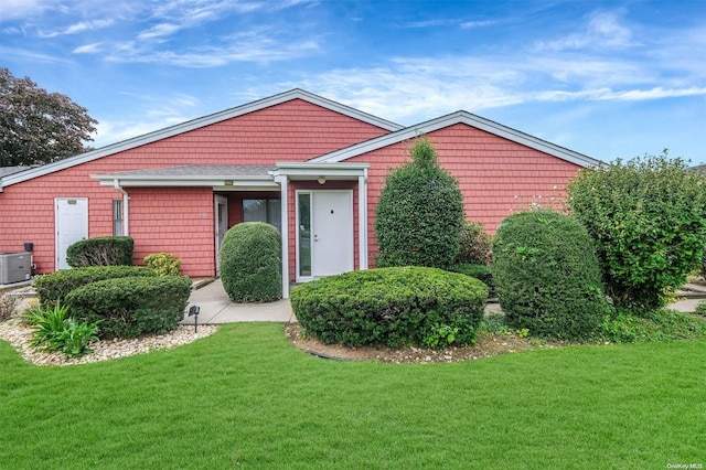 view of front of home featuring central AC unit and a front yard