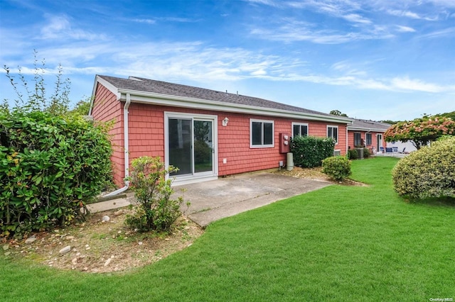 back of property with a yard and a patio