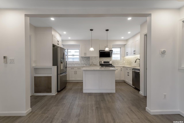 kitchen with hanging light fixtures, stainless steel appliances, white cabinetry, and dark hardwood / wood-style floors