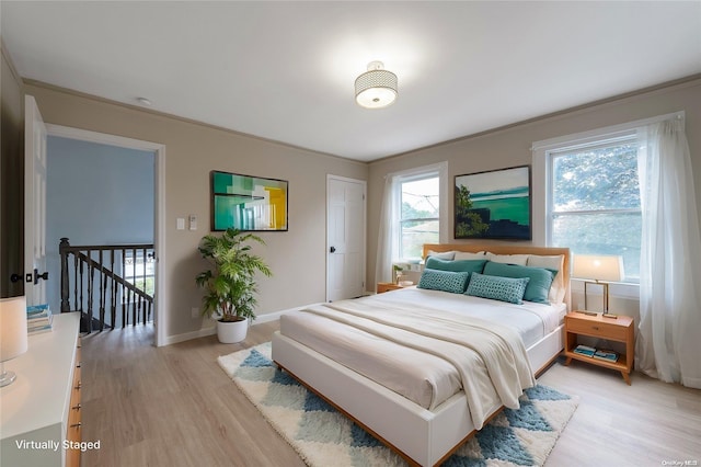 bedroom featuring light hardwood / wood-style floors and ornamental molding