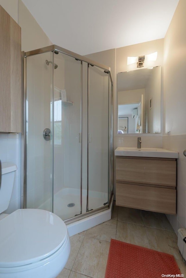 bathroom featuring vanity, toilet, tile walls, and walk in shower