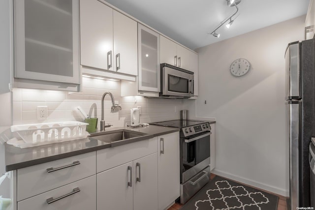 kitchen featuring white cabinetry, sink, dark hardwood / wood-style floors, decorative backsplash, and appliances with stainless steel finishes