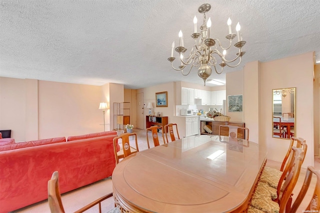 dining room with light colored carpet, a chandelier, and a textured ceiling