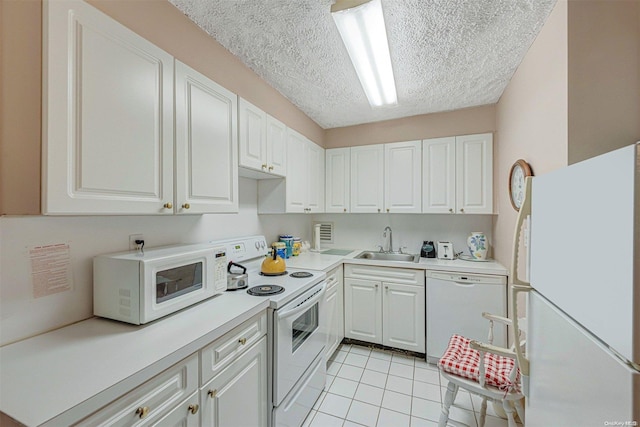 kitchen featuring white cabinets, white appliances, sink, and light tile patterned floors