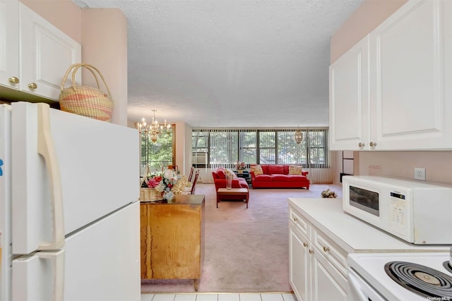 kitchen featuring white cabinets, white appliances, and a textured ceiling