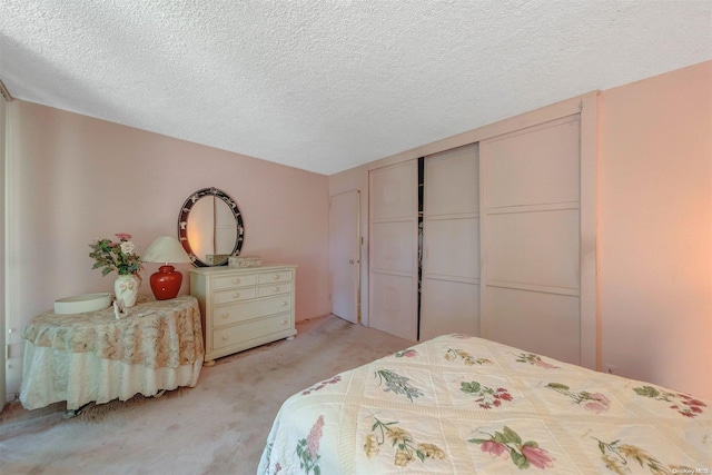 bedroom with light carpet, a closet, and a textured ceiling