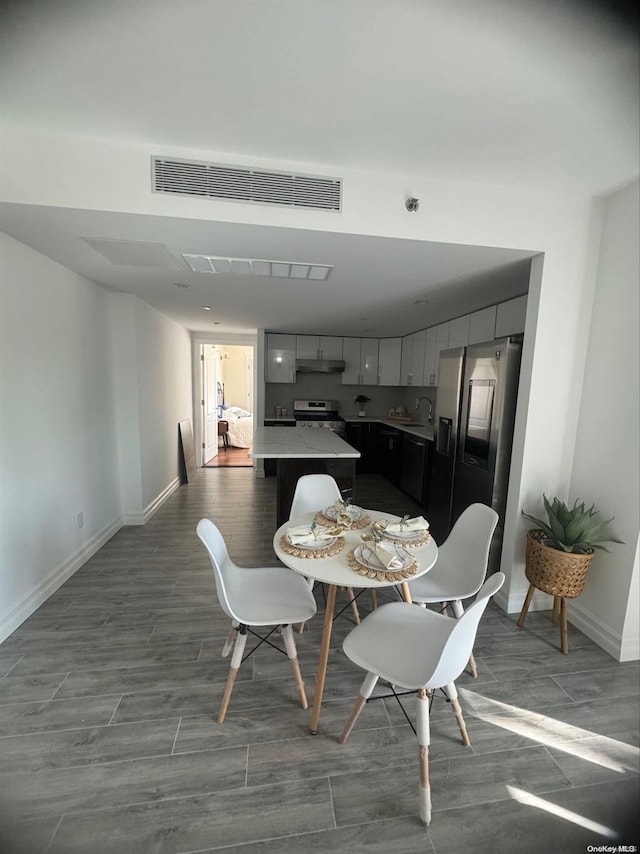 dining room with wood-type flooring and sink