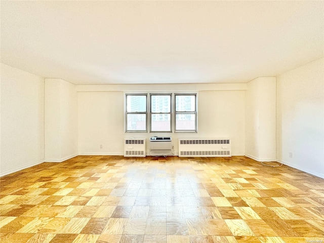 empty room with light parquet flooring, radiator, and heating unit