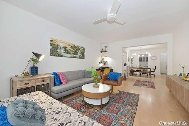 living room featuring light hardwood / wood-style flooring and ceiling fan with notable chandelier