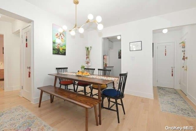 dining room with a notable chandelier and light hardwood / wood-style flooring