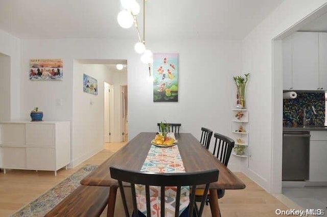 dining area with light hardwood / wood-style flooring and sink