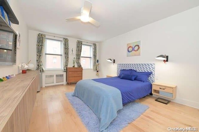 bedroom with radiator, ceiling fan, and light hardwood / wood-style floors