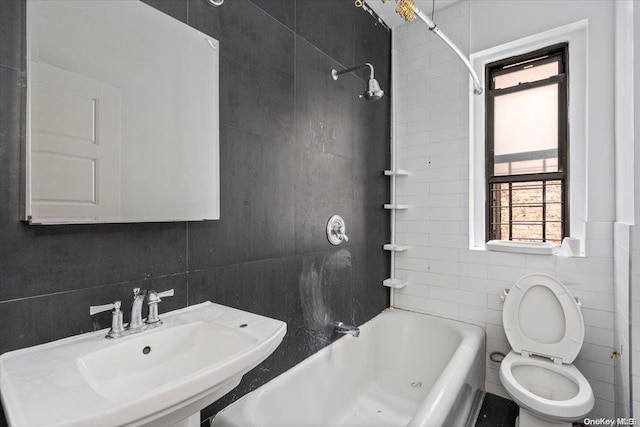 full bathroom with decorative backsplash, sink, tile walls, toilet, and tiled shower / bath