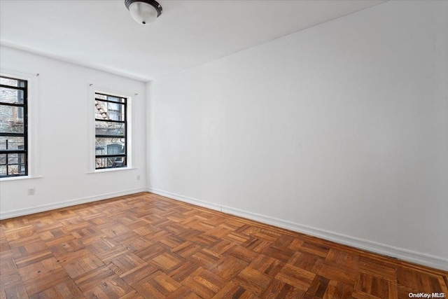 unfurnished room with dark parquet flooring